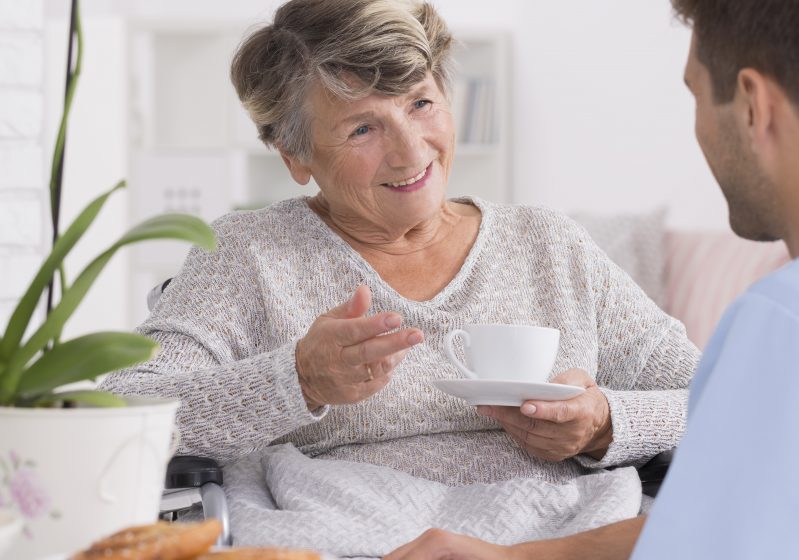 Grandmother talking with caregiver during tea time