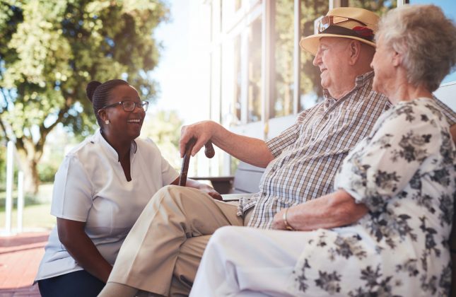 senior-couple-with-caregiver-sitting-outside-21